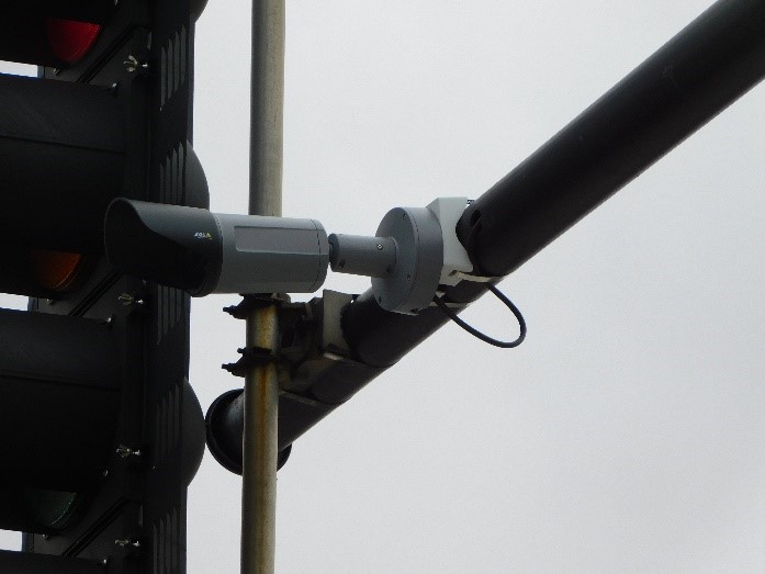 security camera mounted to a pole at a stop light