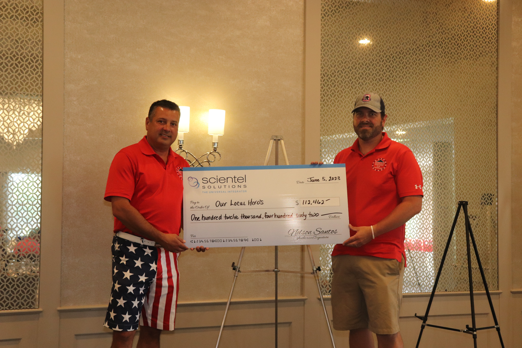 Nelson Santos, CEO of Scientel Solutions holding a donation check to a local veteran organization.